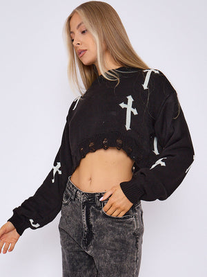 Black knitted crop jumper with white crucifix print, cutout ribbed hem and long sleeves