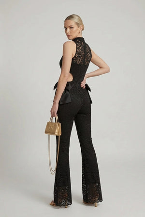 Black lace halter jumpsuit with cut-out back and flared legs, satin bow at waist
