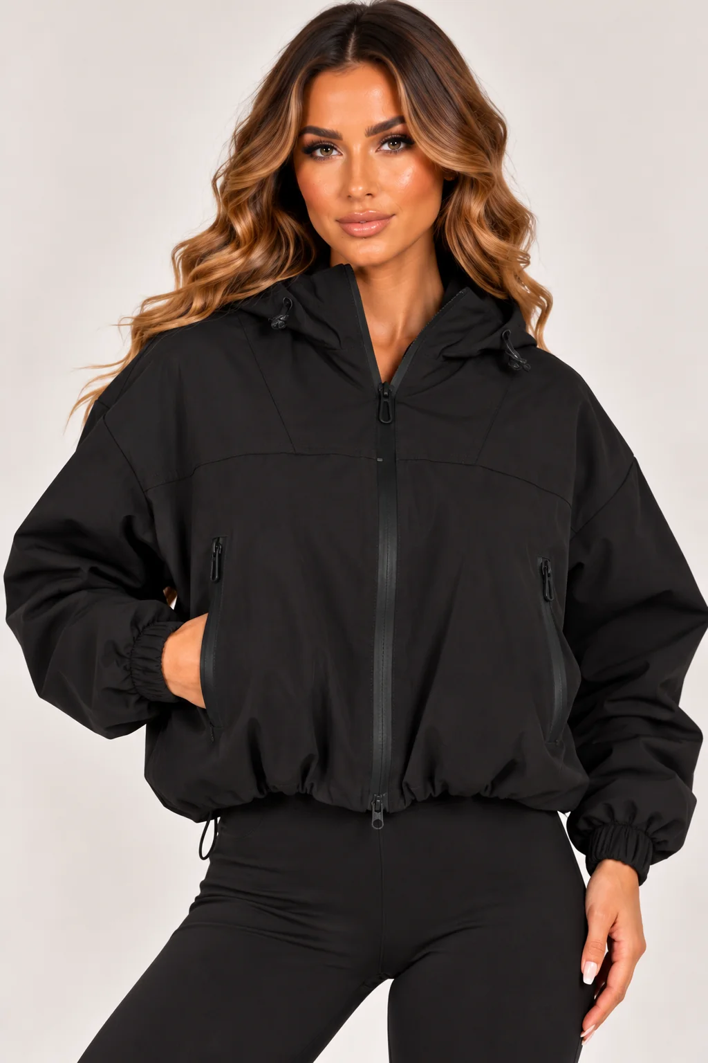 Black hooded zip-up windbreaker jacket with stand collar, zip front, and zip pockets