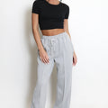 Light grey wide-leg joggers with elastic waist and drawstring, roomy relaxed fit.