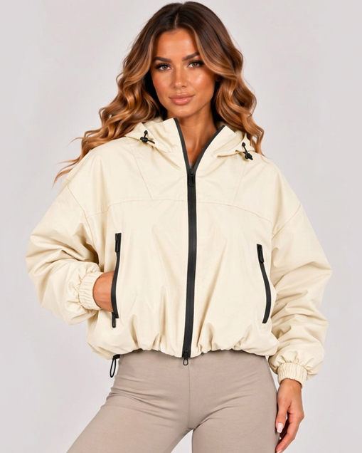 Beige hooded zip-up windbreaker jacket with zip front, zip pockets, and elastic cuffs