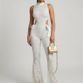 White lace halter jumpsuit with flared bell legs and cut-out sides, satin bow at waist
