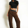 Brown wide-leg trousers with banded elastic waist and contrast stripe, full body view.