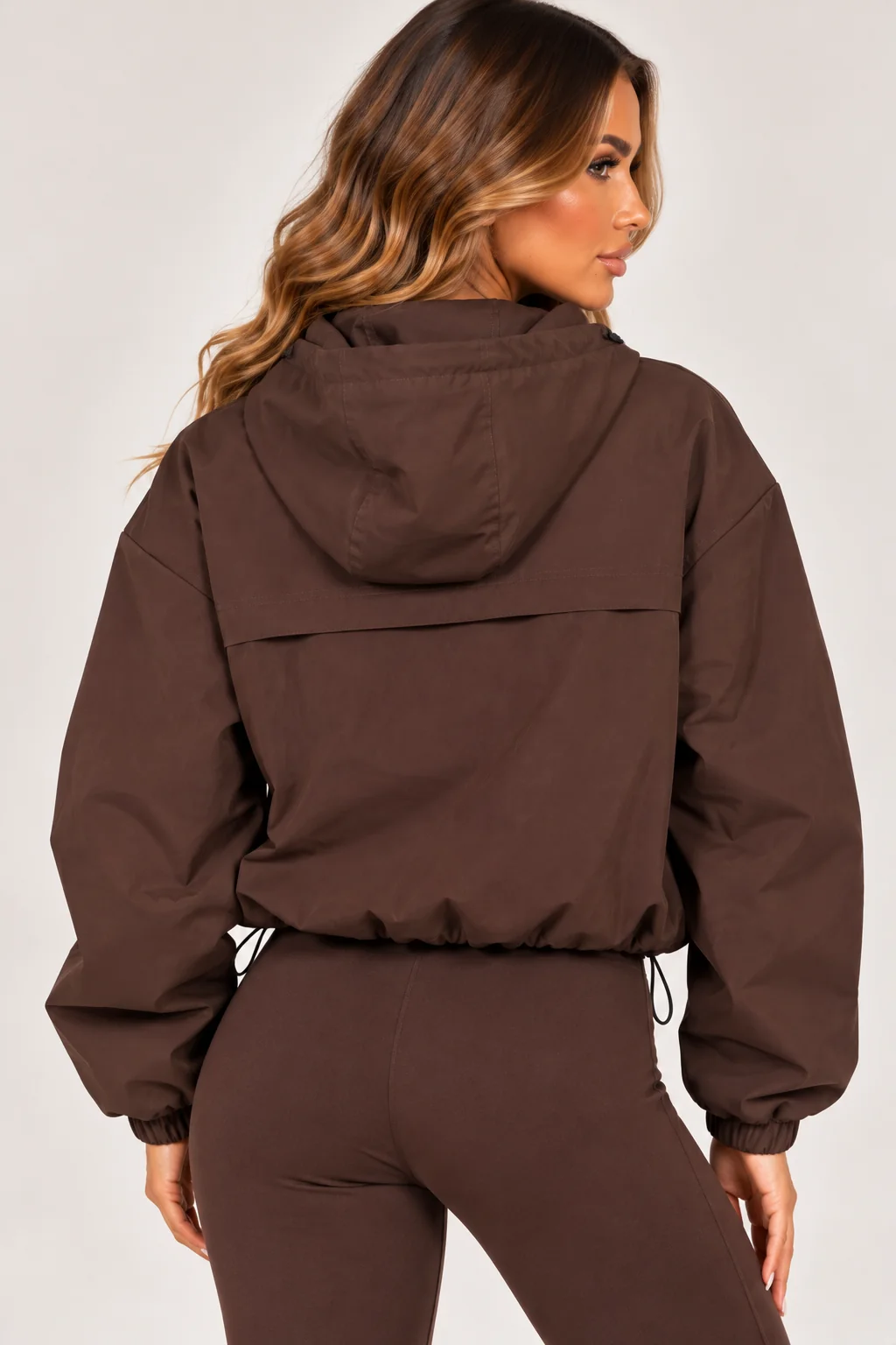 Brown hooded zip-up windbreaker jacket, rear view with elastic cuffs and pocket zips