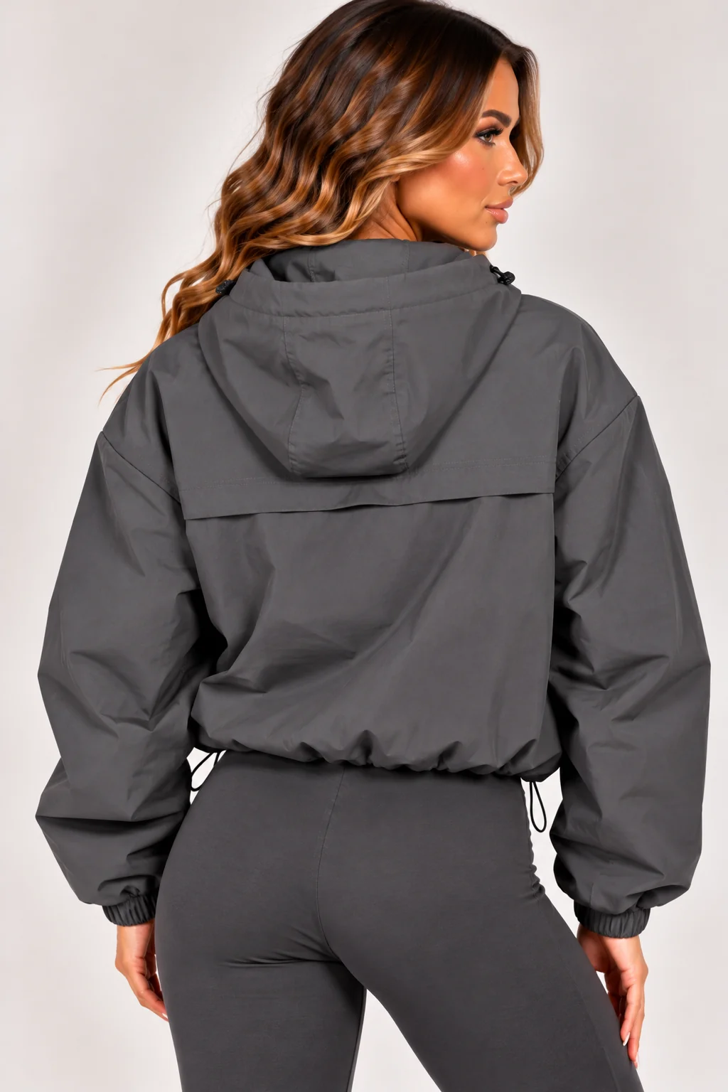 Grey hooded zip-up windbreaker jacket, rear view with elastic cuffs and pocket zips
