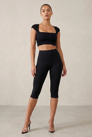 Black Capri leggings shown with a cropped square-neck top.