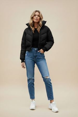 Black quilted puffer jacket with hood and front zipper, worn with blue jeans.