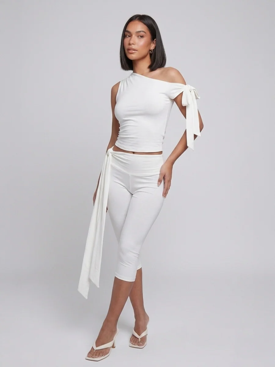 White two-piece set with an asymmetric tie-shoulder top and cropped tie-waist leggings