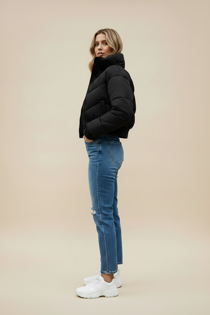 Black quilted puffer jacket with hood and front zipper; side profile view.