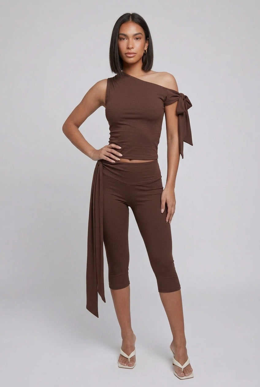 Brown two-piece set with an asymmetric tie-shoulder top and cropped tie-waist leggings