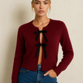 Wine red knitted lace-up cardigan with black bow ties at center front, long sleeves