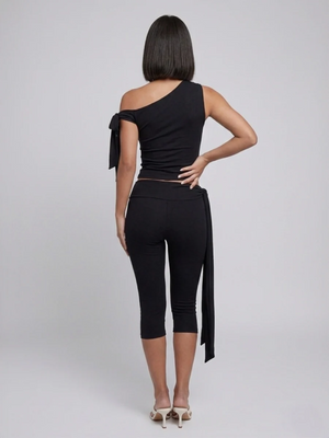 Black two-piece set, back view showing the asymmetric top and cropped tie-waist leggings