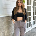 Black cropped open blazer with ruched sleeves, front pockets, and notch lapel